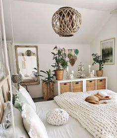 a bedroom with white bedding and lots of plants