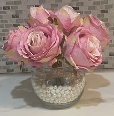 some pink roses and pearls in a vase