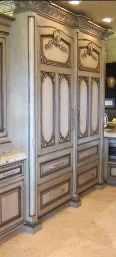 an ornately decorated kitchen with marble counter tops and cabinets in grey, gold and white