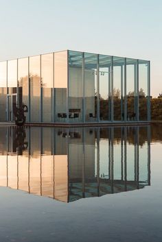 a glass building sitting on top of a body of water