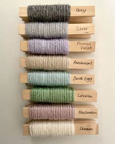 six skeins of yarn in different colors and sizes with names on each skein