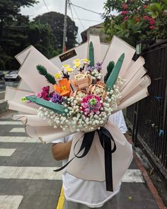 a woman holding a bouquet of flowers on the street