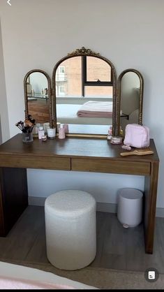 a vanity table with a mirror and stool