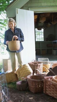 a woman standing in front of a pile of baskets