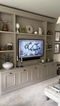 a living room filled with furniture and a flat screen tv mounted on a wall above it