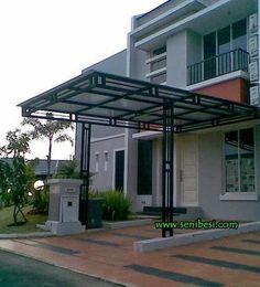 an empty street in front of a building with a metal structure on the side of it