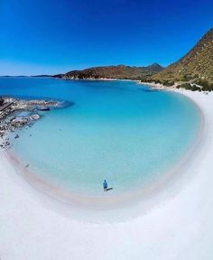 an aerial view of a beach with clear blue water