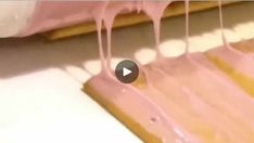 pink icing is being poured onto the floor