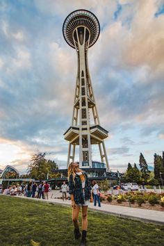 a woman standing in front of a tall tower