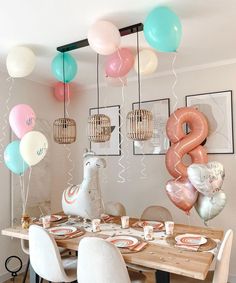 balloons are hanging from the ceiling above a dining room table