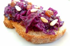 two pieces of bread with red cabbage and almonds on top, sitting on a white surface