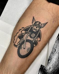 a person with a tattoo on their arm holding an object in the shape of a skull