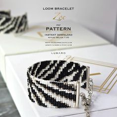 a bracelet with black and white stripes is shown on a box next to a chain