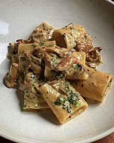 a white bowl filled with pasta covered in sauce