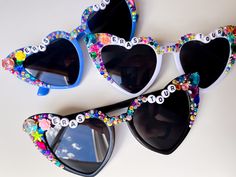 Get ready to make the whole place ✨ shimmer ✨ in these custom and one-of-a-kind sunglasses! 💖 Please select the frame color that you want. You will include the word you want them to say in the personalization box when you order. All say have a rainbow assortment of gems, unless you message me about something different. Please note that due to the unique handmade nature of these sunglasses, no two are the same and there will be variation in specific gem color and placement. All will be very simi Eras Sunglasses, Eras Tour Themed Party, Eras Tour Sunglasses, Taylor Swift Party Favors, Taylor Swift Sunglasses, Bedazzled Sunglasses, Taylor Swift House, Festival Glasses, Eras Bracelets