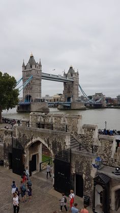 people are walking around in front of the tower bridge