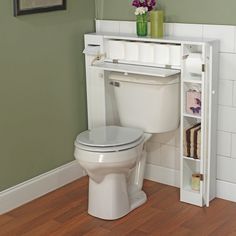 a white toilet sitting in a bathroom next to a book shelf