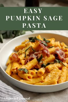 creamy pumpkin prosciutto pasta with sage in a white bowl on a table