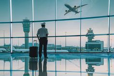 a man standing in front of an airport window