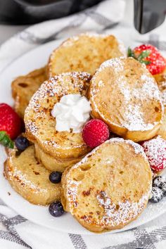 french toast on a plate with berries and whipped cream