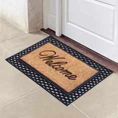 a welcome mat on the ground in front of a door