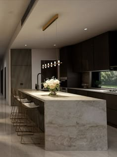 a kitchen with marble counter tops and bar stools next to an open floor plan