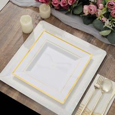 a white plate with yellow trim on it next to pink roses and candles in vases