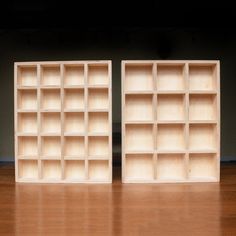 two empty wooden shelves sitting on top of a hard wood floor next to each other