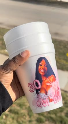 a person holding up a coffee cup with an image of a woman on the side