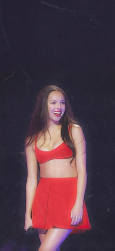 a woman in a red dress standing on stage