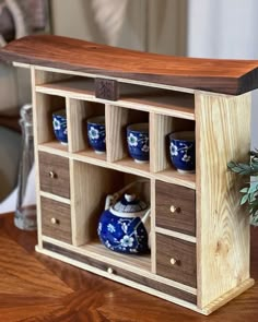 a wooden shelf with blue and white vases on it