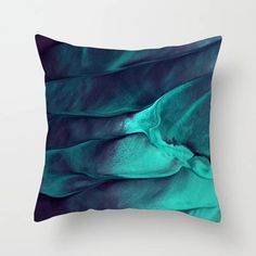 a blue and green pillow on a white wall