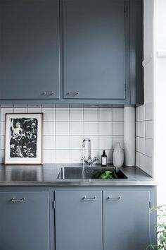 a kitchen with gray cabinets and stainless steel counter tops is seen in this image from the front view