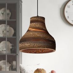 a lamp hanging from a ceiling next to a table with plates and bowls on it