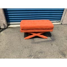 an orange bench sitting in front of a blue garage door