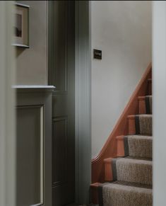 an open door leading to a set of stairs with carpet on the bottom and top