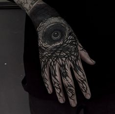 a man with tattoos on his hand and an eye tattoo