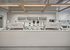 a white counter topped with lots of cups and saucers on top of it's sides