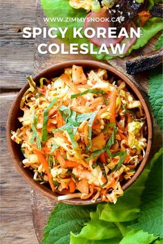 a wooden bowl filled with coleslaw next to lettuce and other vegetables