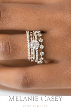 a woman's hand with a ring on it and two diamonds in the middle