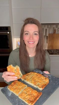 a woman is holding up some food on a tray in her hands and smiling at the camera