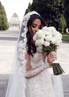 a woman in a wedding dress holding a bouquet of flowers