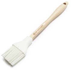 a white paint brush with wooden handle on a white background for use in crafts and painting