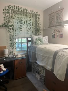 a bedroom with a bed, desk and window covered in green ivys on the wall