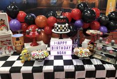 a birthday party with black, white and red balloons in the shape of checkers