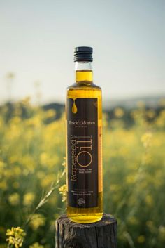 a bottle of oil sitting on top of a wooden post