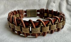 This rugged unisex bracelet looks great on just about anybody! This piece is handmade of embossed brown strap leather, brass chain, brown leather cord and finished with a metallic clasp for easy on and off. Fits a size 6.5 inch wrist snugly, but not tight.  Please note sizing! To measure your wrist, take a tape measure and wrap it snugly (with no slack) around your wrist. (I build in extra space for it to hang/fit properly.) If you have questions, please contact me! I'm happy to make a custom size for you. Brown Steampunk Jewelry Gift, Vintage Brown Everyday Bracelets, Steampunk Brown Jewelry Gift, Steampunk Brown Jewelry For Gift, Steampunk Brown Jewelry For Gifts, Everyday Vintage Brown Bracelets, Brown Leather Bracelets With Brass Hardware, Vintage Brown Metal Bracelets, Brown Rectangular Leather Strap Bracelet