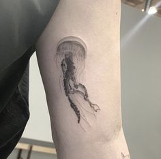 a jellyfish tattoo on the left arm