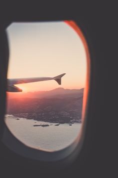 the view out an airplane window at sunset