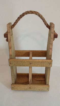 a small wooden basket with rope on the top and bottom, sitting on a white surface